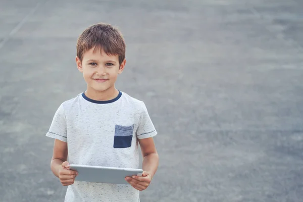 Miúdo sorridente com tablet. Escola, educação, tecnologia, conceito de lazer — Fotografia de Stock