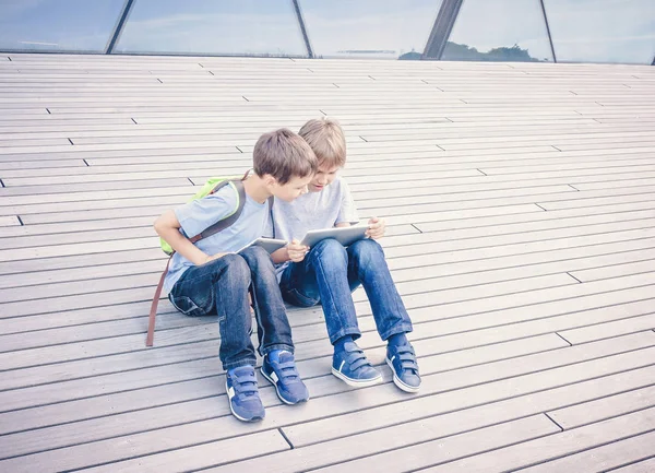 Dos chicos jugando o navegando por Internet en tabletas digitales — Foto de Stock