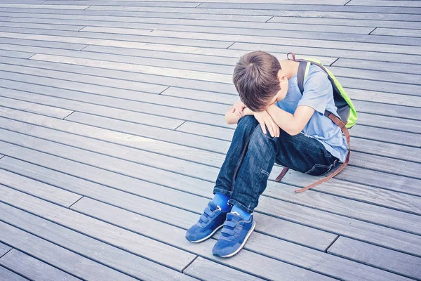 Trauriges, einsames, unglückliches, enttäuschtes Kind, das allein auf dem Boden im Freien sitzt — Stockfoto