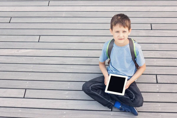 Um miúdo com computador tablet. Escola, educação, tecnologia, conceito de lazer — Fotografia de Stock