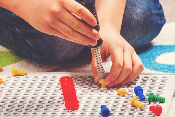 Primer plano de las manos de los niños jugando con el kit de herramientas de juguetes. Vista superior —  Fotos de Stock