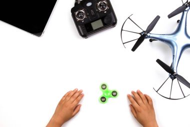 Çocuklar el, topluca spinner oyuncak, dron, uzaktan kumanda ve beyaz zemin üzerine tablet bilgisayar.