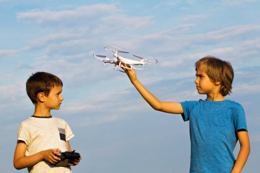 Açık havada drone ile oynayan çocuklar.