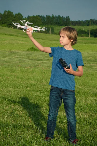 Niño con el dron y el control remoto al aire libre . — Foto de Stock