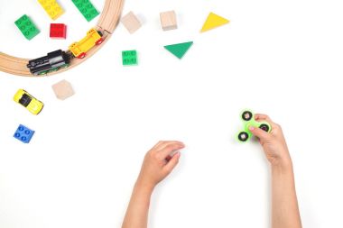 Eller topluca spinner oyuncakla oynamak çocuklar. Beyaz arka plan üzerinde birçok renkli oyuncaklar.