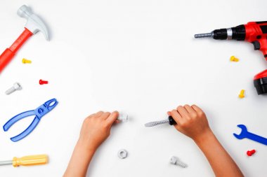 Beyaz arka plan üzerinde renkli oyuncaklar araçlarıyla Childs'ın ellerinde Üstten Görünüm.