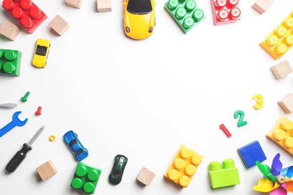 Marco de juguetes para niños con bloques de construcción, cubos, herramientas de juguete y coches sobre fondo blanco. Vista superior . — Foto de Stock