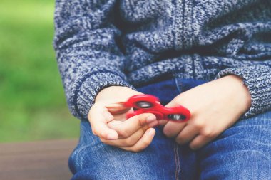 Boy with a fidget spinner outdoors clipart