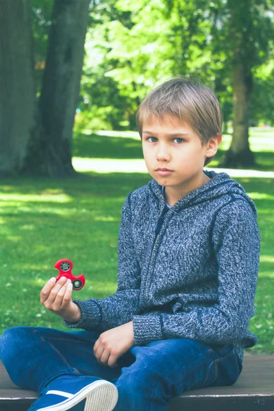 Menino com um fidget spinner ao ar livre — Fotografia de Stock