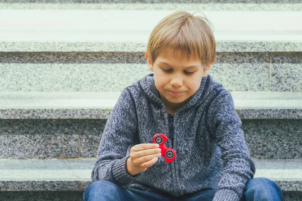 Boy with a fidget spinner outdoors — Stock Photo, Image