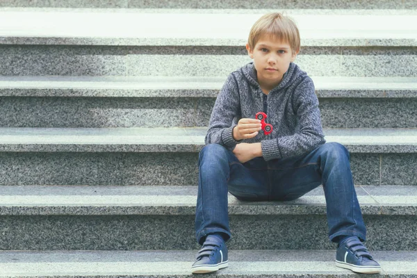 Niño con un fidget spinner al aire libre — Foto de Stock