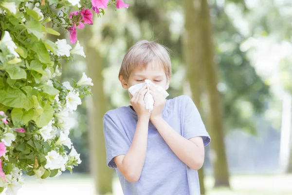 stock image Allergy. Kid is blowing nose with tissue paper at the park