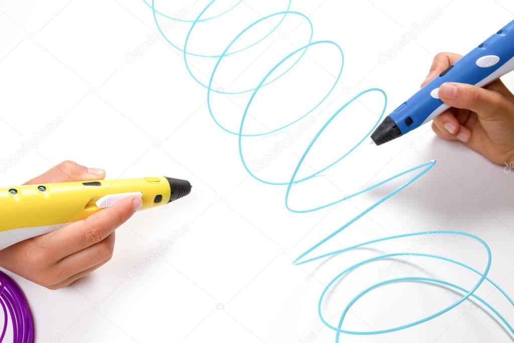 Kids hands holding 3d printing pens with filaments on white background. Top view