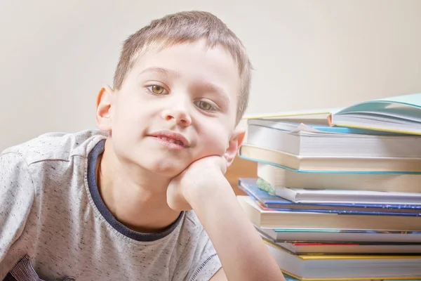 Μικρό αγόρι κοντά σε στοίβα από πολύχρωμα βιβλία — Φωτογραφία Αρχείου