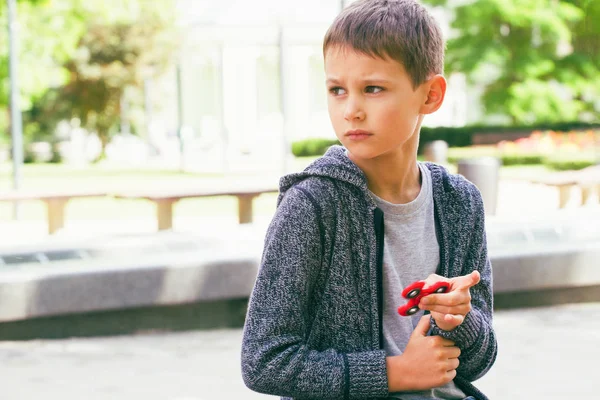 Niño con un fidget spinner al aire libre —  Fotos de Stock