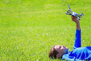 Açık havada çim üzerinde yalan dron çocukla.