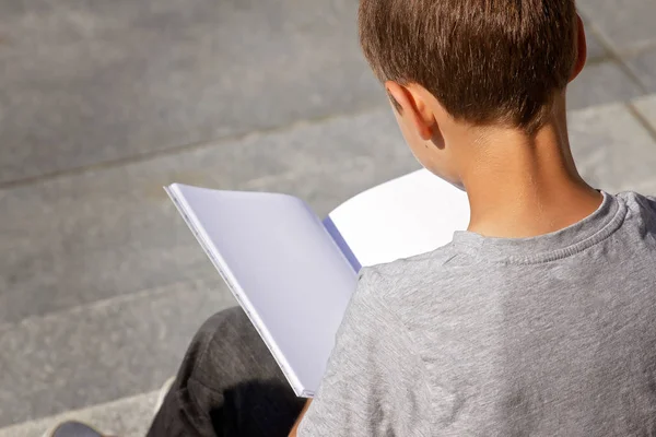Young Boy leesboek buitenshuis — Stockfoto