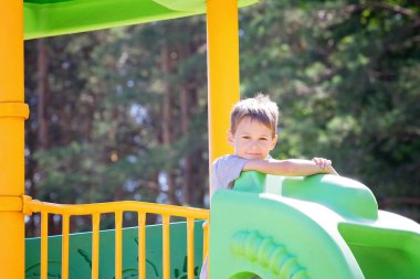 Küçük çocuk oyun alanı üzerinde açık havada yaz aylarında eğleniyor