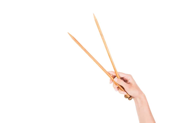 Mano de mujer sosteniendo dos agujas de punto de madera aisladas sobre fondo blanco — Foto de Stock