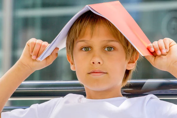 Kind met boek over zijn hoofd — Stockfoto