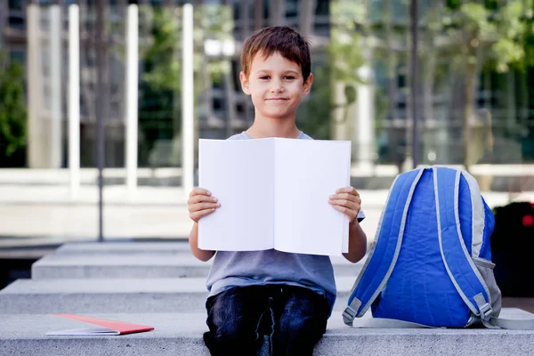 小男孩抱着空白打开笔记本与文本的副本空间 — 图库照片