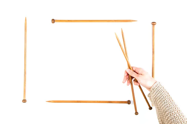 Fundo de tricô. Mulher mão e agulhas de tricô de madeira no fundo branco — Fotografia de Stock