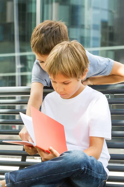 Children doing homework in the city outdoors. — Stock Photo, Image