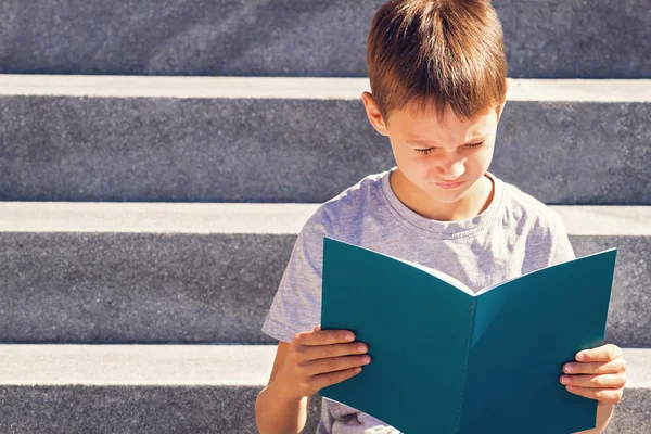 Schooljongen lezen van boeken. Kind huiswerk buitenshuis. Terug naar school concept. — Stockfoto