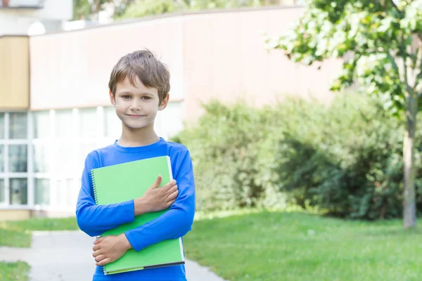 Jongen bedrijf boekje buitenshuis — Stockfoto