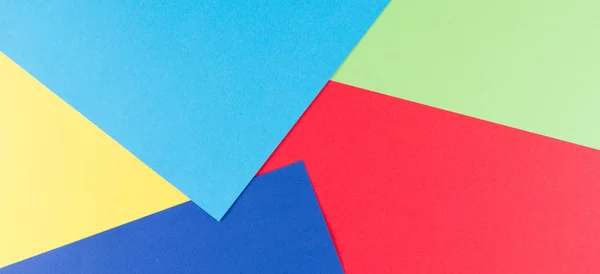 Papel de cor geometria composição plana fundo com tons amarelos, verdes, vermelhos e azuis — Fotografia de Stock