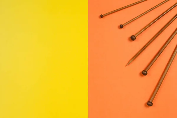 Variedad de agujas de punto de bambú en diferentes tamaños sobre fondo amarillo y naranja — Foto de Stock