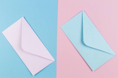 Pembe ve mavi zarfların pembe ve mavi renkli arka plan üzerinde. Üstten Görünüm.