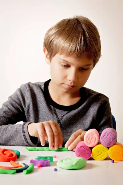 Menino jogando e criando a partir de argila de modelagem ou plasticina . — Fotografia de Stock