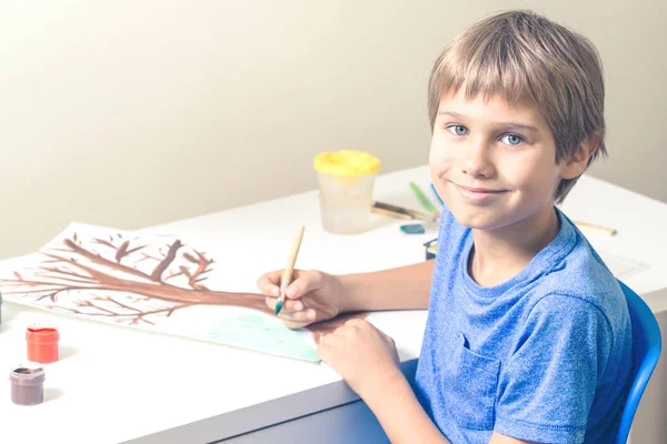 Αγόρι ζωγραφική με πινέλο και πολύχρωμο γκουάς και ακουαρέλα χρώματα. — Φωτογραφία Αρχείου