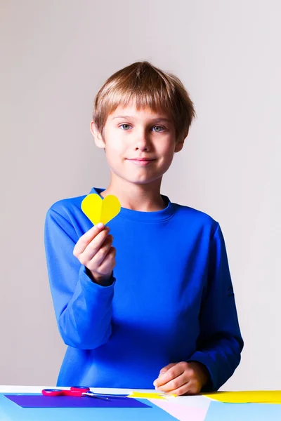 Niño haciendo tarjeta de felicitación con corazones coloridos — Foto de Stock
