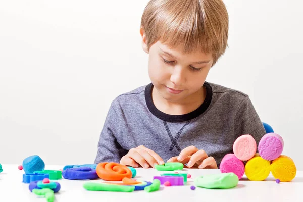 Menino jogando e criando a partir de argila de modelagem ou plasticina . — Fotografia de Stock