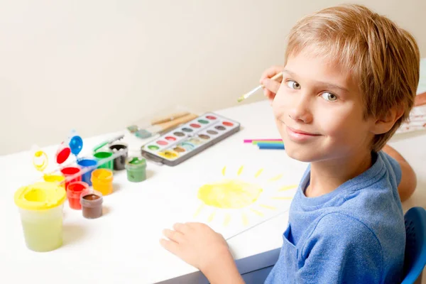 Happy kid ζωγραφική με πινέλο και πολύχρωμα χρώματα ακουαρέλα. — Φωτογραφία Αρχείου