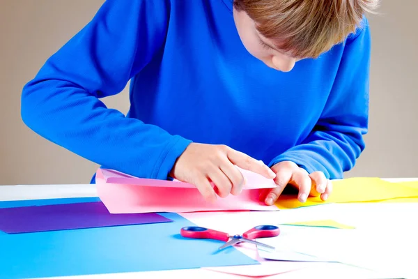Kid składany papier kolorowy i Dokonywanie origami. — Zdjęcie stockowe