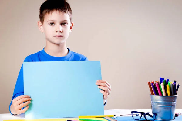 Dítě výrobu blahopřání. Chlapec s list barevného papíru — Stock fotografie