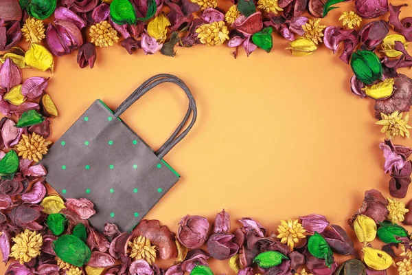 Fekete és zöld polka dot könyv bevásárló táska körül színes szárított virágok és levelek keret. — Stock Fotó