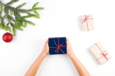 Mevcut bir kutu holding çocuk eller craft kağıt ve Noel ağacı dalı ve dekorasyon beyaz arka plan üzerinde paketlenmiş küçük hediye kutuları ile Noel arka plan