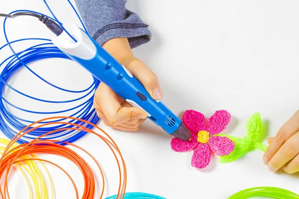 La mano del niño sostiene la pluma azul de la impresión 3D y hace nuevo artículo — Foto de Stock