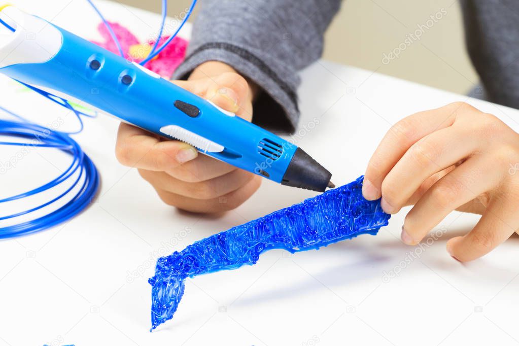 Kids hands creating with 3d printing pen.
