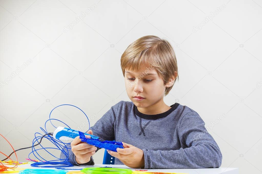 Focused child creating with 3d printing pen
