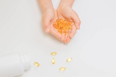 Balık yağı omega 3 kapsülleri elinde beyaz arka plan üzerinde