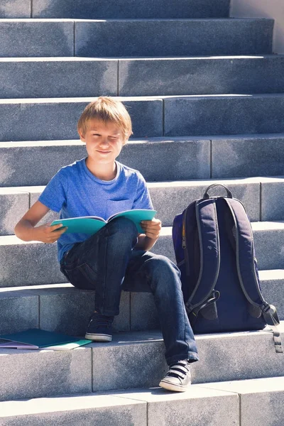 Μαθητής ανάγνωση βιβλίων. Παιδί που κάνει την εργασία σε εξωτερικούς χώρους. Πίσω στο σχολείο έννοια. — Φωτογραφία Αρχείου