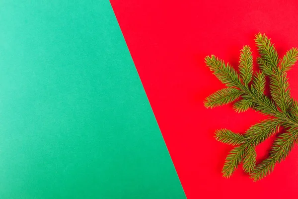 Fundo de Natal. Ramo de abeto verde no fundo vermelho e verde . — Fotografia de Stock