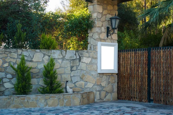 Mock up near the gate to the private house yard. Wooden gates and a high stone fence — Stock Photo, Image