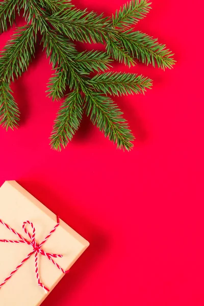 Composição de Natal em fundo vermelho. Ramo de abeto verde e caixa de presente — Fotografia de Stock