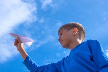 Çocuk atma beyaz kağıt uçak.